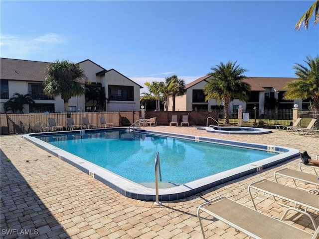 pool featuring a patio, a community hot tub, and fence