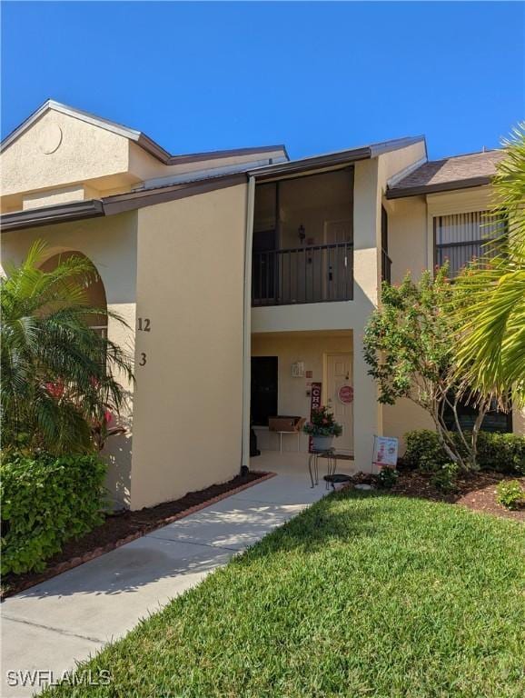 exterior space featuring a yard and a balcony