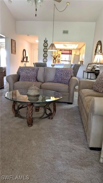 carpeted living room with a ceiling fan, visible vents, and a healthy amount of sunlight