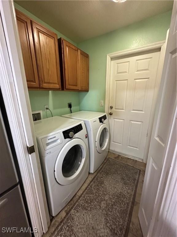 washroom with cabinets and washer and clothes dryer