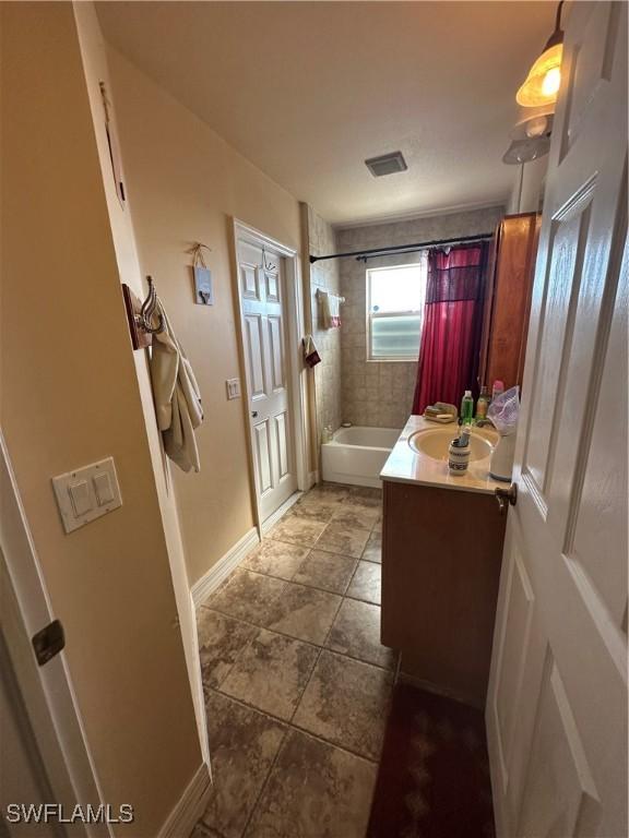 bathroom with shower / tub combo and vanity