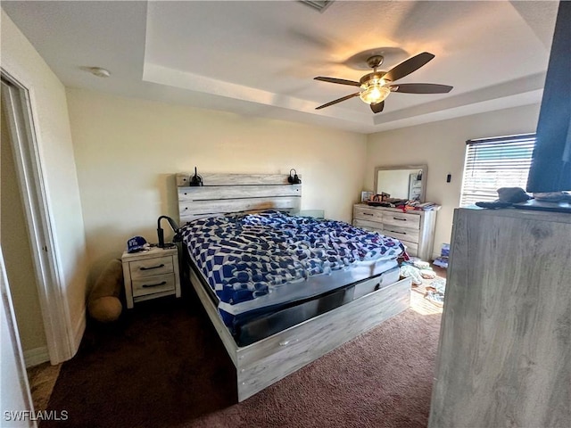 bedroom with a raised ceiling and ceiling fan