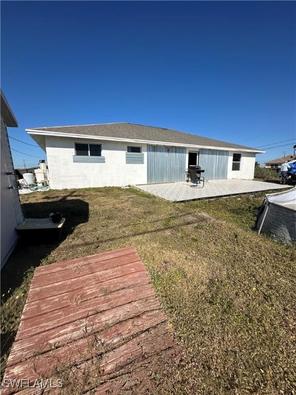 rear view of property with a patio area and a lawn