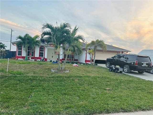 view of front of home featuring a lawn and a garage