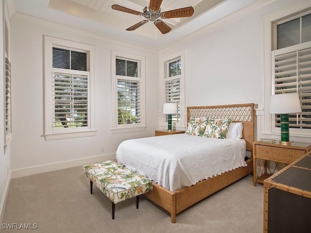 bedroom featuring a tray ceiling, ceiling fan, light colored carpet, and ornamental molding