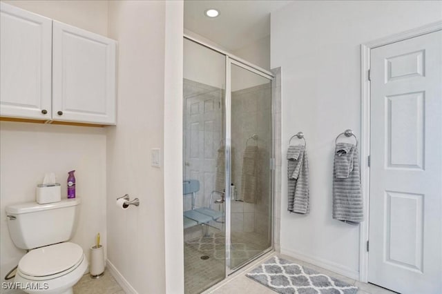 bathroom featuring tile patterned flooring, toilet, and an enclosed shower