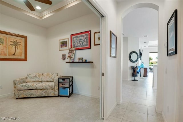 corridor featuring light tile patterned floors and a raised ceiling