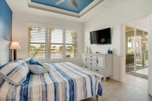 bedroom with access to outside, crown molding, ceiling fan, and a tray ceiling