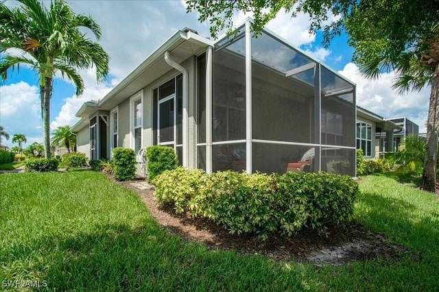 view of property exterior featuring a lawn and a lanai