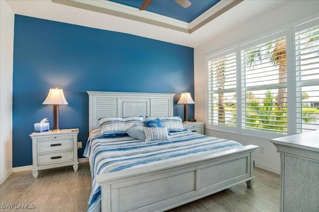 bedroom with light hardwood / wood-style floors, crown molding, and multiple windows