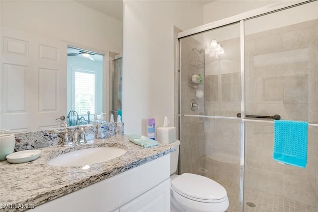 bathroom featuring vanity, an enclosed shower, and toilet