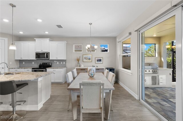 dining space with sink and an inviting chandelier