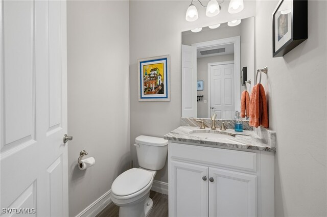 bathroom featuring hardwood / wood-style flooring, vanity, and toilet