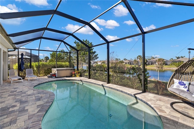 view of swimming pool featuring a water view, a hot tub, glass enclosure, and a patio area