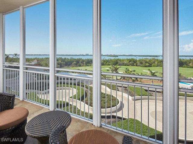 sunroom featuring a water view