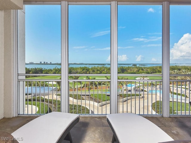 sunroom / solarium with plenty of natural light and a water view