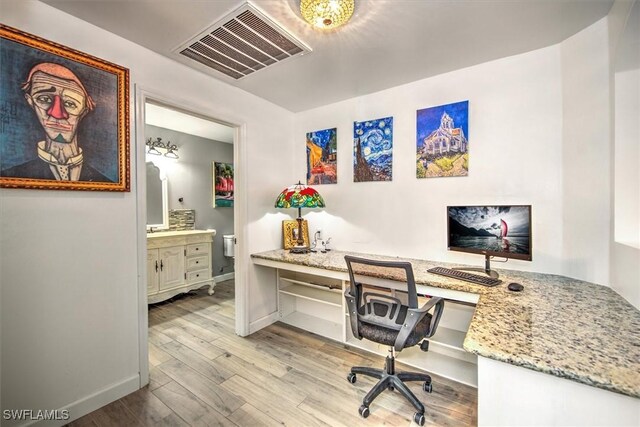 office area featuring built in desk and light hardwood / wood-style floors