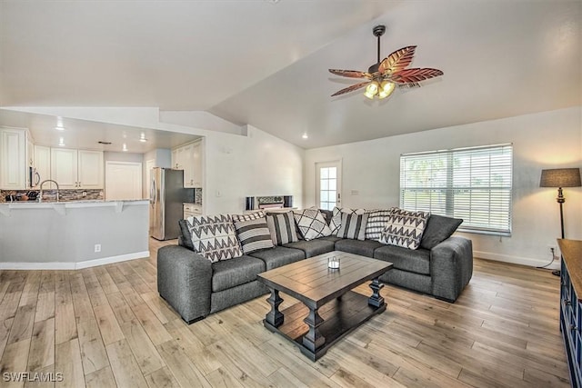 living room with light hardwood / wood-style flooring, vaulted ceiling, and ceiling fan