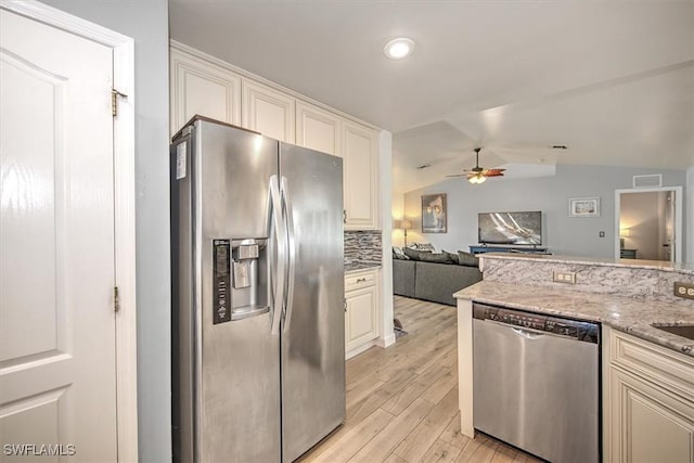 kitchen with light stone counters, light hardwood / wood-style flooring, backsplash, lofted ceiling, and appliances with stainless steel finishes