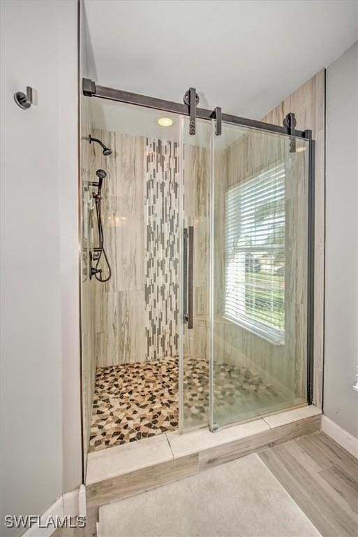 bathroom featuring wood-type flooring and an enclosed shower