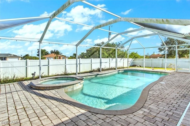 view of swimming pool with glass enclosure, an in ground hot tub, and a patio area