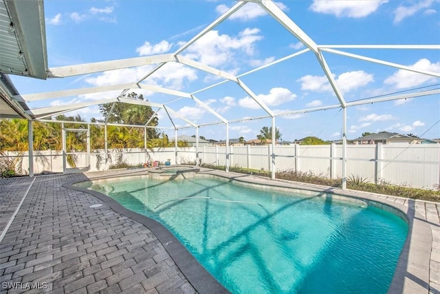 view of swimming pool featuring an in ground hot tub, a patio area, and a lanai