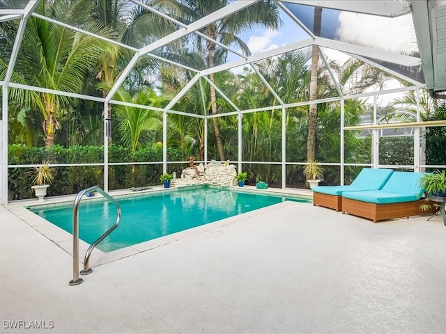 view of swimming pool featuring glass enclosure and a patio area