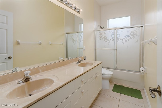 full bathroom with combined bath / shower with glass door, vanity, tile patterned floors, and toilet