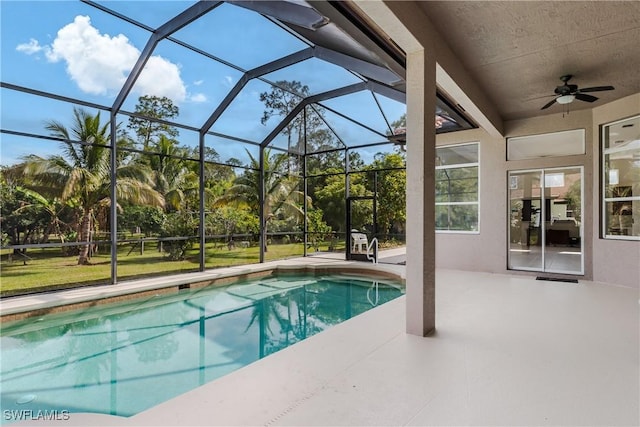 view of pool with a lanai, ceiling fan, and a patio