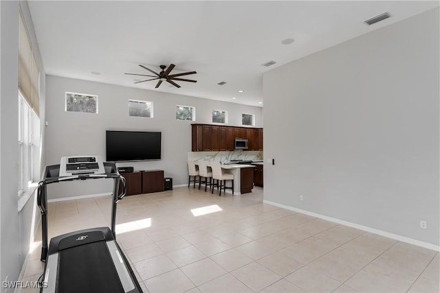 workout room featuring light tile patterned flooring, plenty of natural light, and ceiling fan