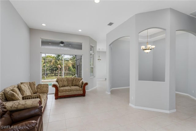 living room with light tile patterned floors and ceiling fan with notable chandelier