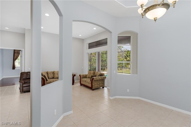 hall featuring a notable chandelier and light tile patterned flooring