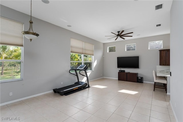 workout area with ceiling fan and light tile patterned floors