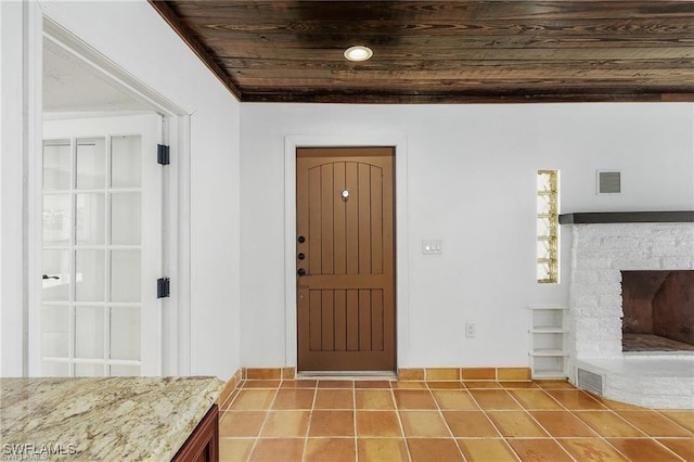 tiled entrance foyer with a fireplace and wooden ceiling