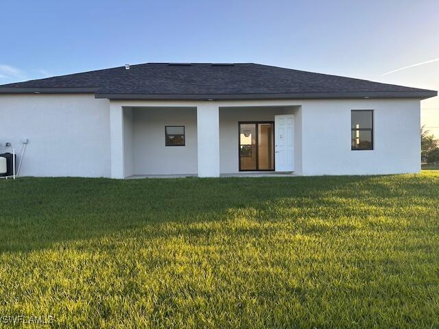 rear view of property with a yard