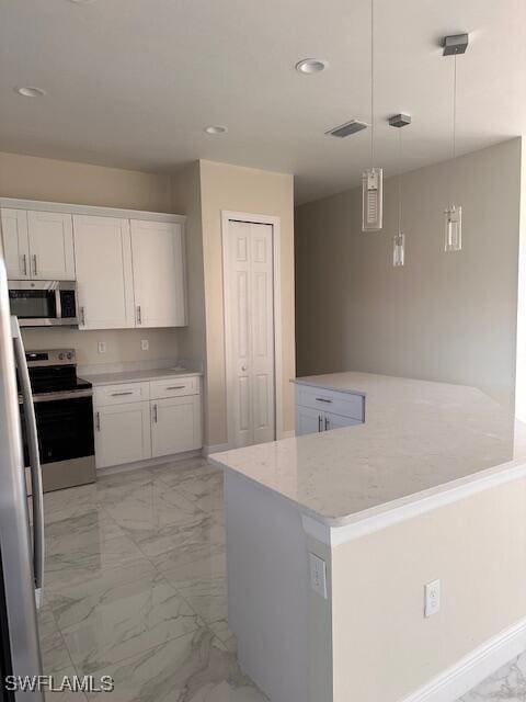 kitchen featuring pendant lighting, light stone countertops, appliances with stainless steel finishes, a kitchen island, and white cabinetry