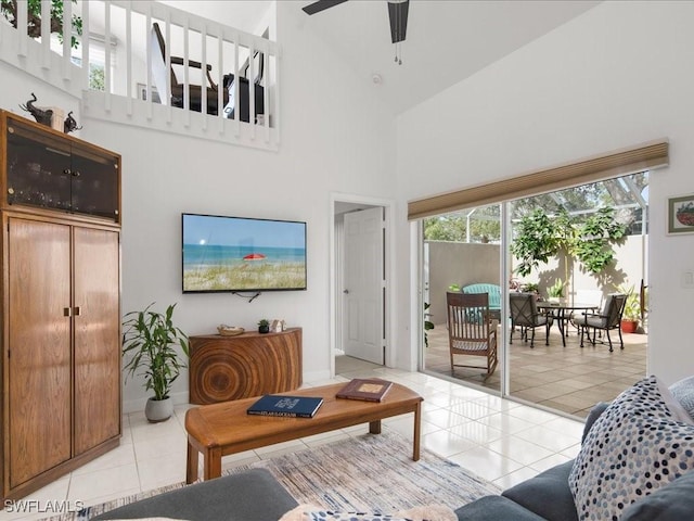 tiled living room with ceiling fan and high vaulted ceiling