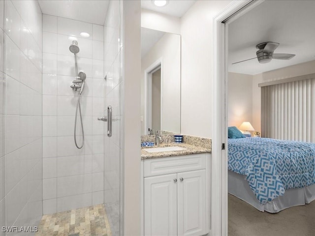 bathroom with ceiling fan, a shower with door, and vanity