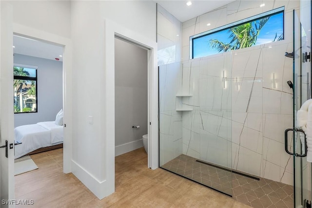 bathroom featuring hardwood / wood-style flooring, toilet, and a shower with door