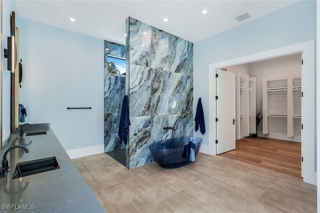 bathroom with separate shower and tub, sink, and wood-type flooring