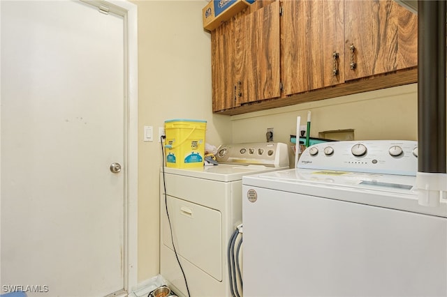 clothes washing area with cabinets and independent washer and dryer