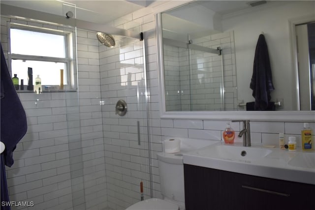 bathroom featuring backsplash, vanity, toilet, and walk in shower