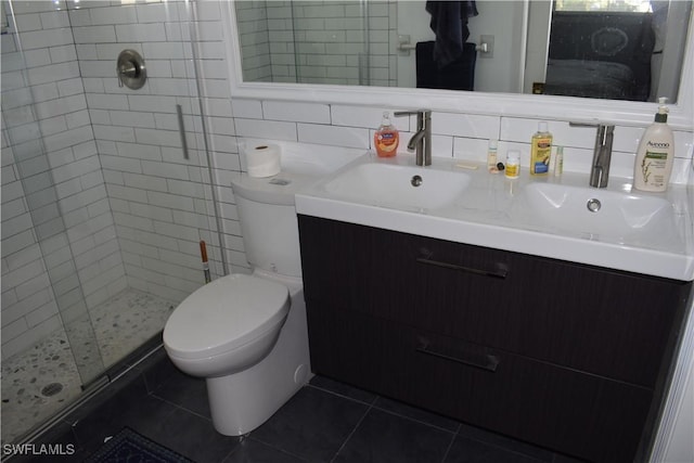 bathroom featuring vanity, tile patterned flooring, decorative backsplash, toilet, and an enclosed shower