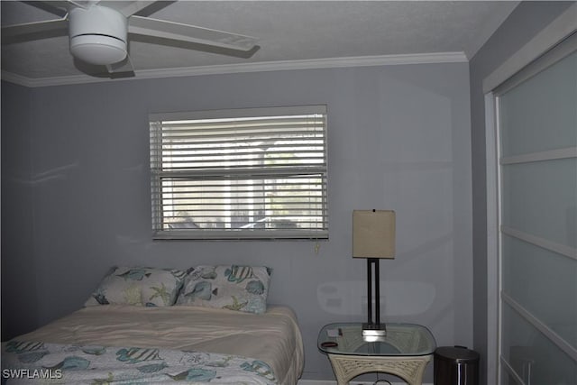 bedroom featuring ceiling fan, a textured ceiling, and ornamental molding