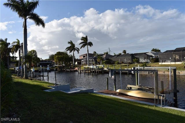 view of dock with a lawn and a water view