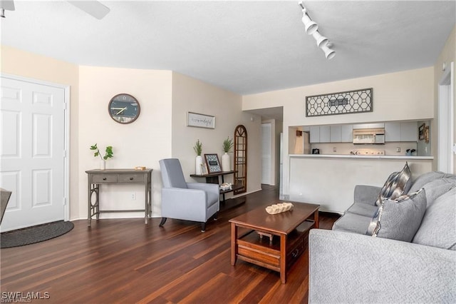 living room with dark hardwood / wood-style floors, ceiling fan, and track lighting