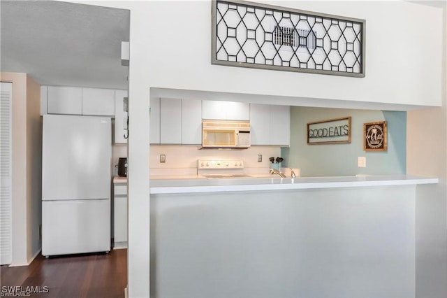 kitchen with white appliances, dark hardwood / wood-style floors, and white cabinetry