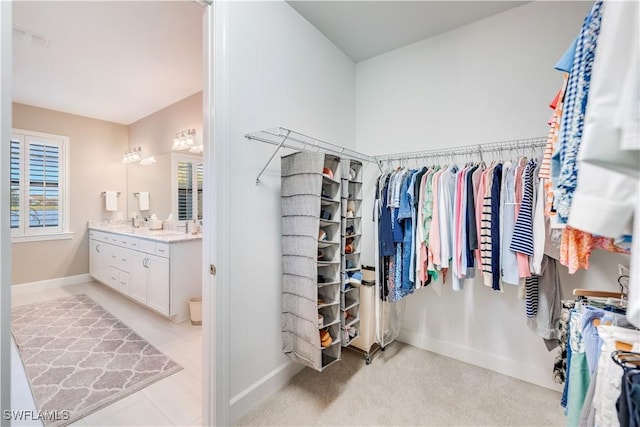 walk in closet with light colored carpet and sink