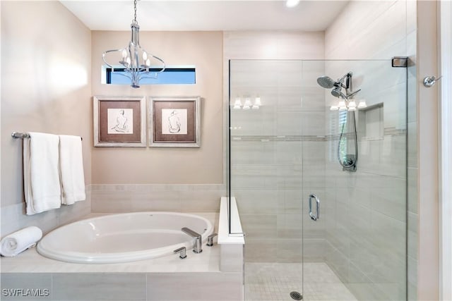 bathroom with independent shower and bath and a chandelier