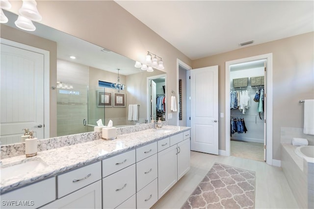 bathroom with shower with separate bathtub and vanity